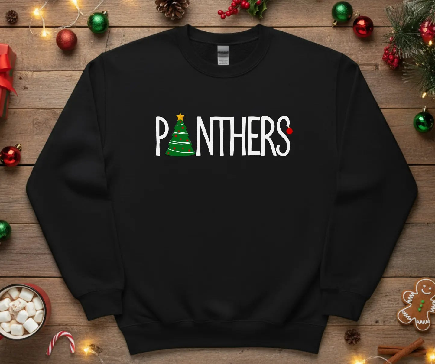 Black sweatshirt with 'PANTHERS' text on a wooden surface with Christmas decorations.