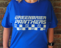 Person wearing a blue 'Greenbrier Panthers' t-shirt against a brick wall.